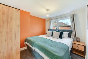 een slaapkamer met een bed met een oranje muur bij Elm-G House in Manchester