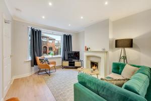 a living room with a green couch and a fireplace at Elm-G House in Manchester