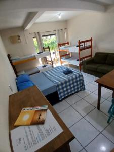 een kamer met een bed, een tafel en een bank bij Pousada Maria do Mar in Garopaba