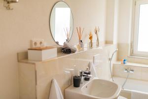 a white bathroom with a sink and a mirror at Auszeit in Radolfzell in Radolfzell am Bodensee