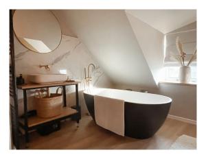 a bathroom with a large bath tub and a sink at Slapen op Tholen in Tholen