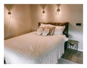 een slaapkamer met een bed met witte lakens en kussens bij Slapen op Tholen in Tholen