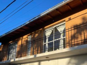 un edificio con un balcón con ventanas. en MAGU en Malargüe