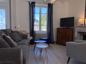ein Wohnzimmer mit einem Sofa und einem TV in der Unterkunft 536 - Maison familiale en bordure de la plage du centre d'Erquy in Erquy
