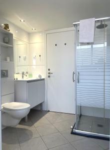 ein weißes Bad mit einem WC und einer Dusche in der Unterkunft 2BR VACATION HOME EILAT in Eilat