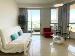 een woonkamer met een bank en een tafel bij 2BR VACATION HOME EILAT in Eilat