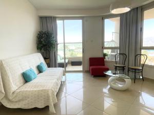 een woonkamer met een bank en een tafel bij 2BR VACATION HOME EILAT in Eilat +26 foto's
