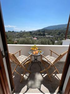 een tafel en stoelen op een balkon met uitzicht bij Jimmy's Guest House Skiathos in Skiathos-stad