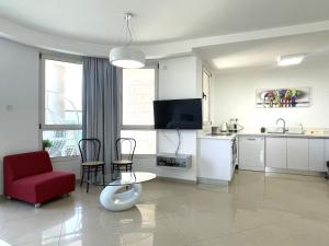 een woonkamer met een rode stoel en een keuken bij 2BR VACATION HOME EILAT in Eilat