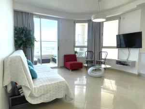 een woonkamer met een bank en een rode stoel bij 2BR VACATION HOME EILAT in Eilat