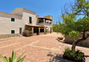 a large white house with a brick driveway at Apartments Campanitx - Astbury Formentera in Es Caló