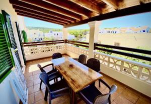 une terrasse couverte avec une table et des chaises en bois sur un balcon dans l'établissement Apartments Campanitx - Astbury Formentera, à Es Caló