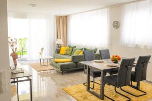 a living room with a couch and a table and chairs at Auszeit in Radolfzell in Radolfzell am Bodensee