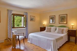 Un dormitorio con una gran cama blanca y una ventana en Frassanelle, en Rovolon