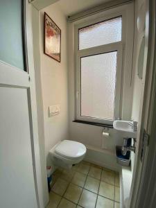 a small bathroom with a toilet and a window at Bel appartement spacieux Verviers in Verviers