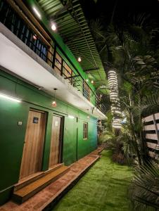 een gebouw met groene muren en een gang met gras bij Seaside Serenity Resort in Mandrem