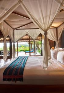 a bedroom with a large bed with a canopy at Villa Blue Steps in Yogyakarta