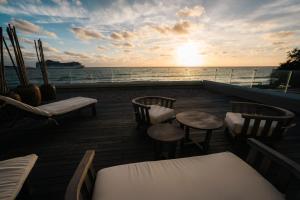 a balcony with chairs and tables and the ocean at Serena Hotel - Punta del Este - Unico sobre la Playa in Punta del Este