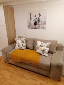 Marienblickappartement - ABC269 في فيسمار: أريكة في غرفة معيشة مع لوحة على الحائط