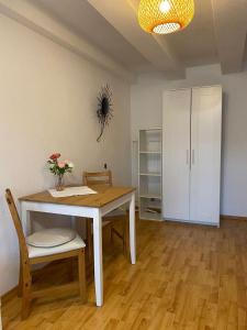 Marienblickappartement - ABC269 في فيسمار: طاولة غرفة طعام مع كرسيين وخزانة بيضاء