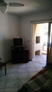 sala de estar con TV y puerta a una habitación en Ilha do Coral Residence, en Florianópolis