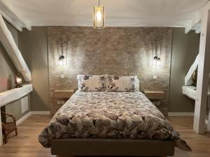 a bedroom with a bed and a brick wall at LA MANSARDE in Aix-les-Bains