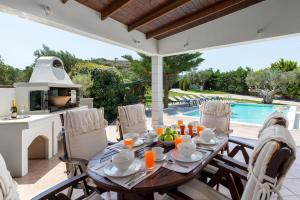 a patio with a table and chairs and a pool at Villa Vergio in Afantou