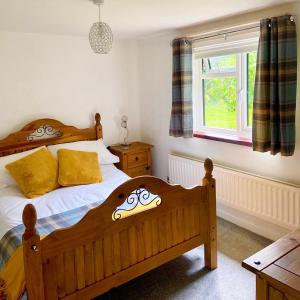 a bedroom with two beds and a window at The Cottage On the Common in Tenbury