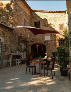 een patio met tafels en stoelen en een bakstenen gebouw bij Azienda agricola Scerba in Montemagno