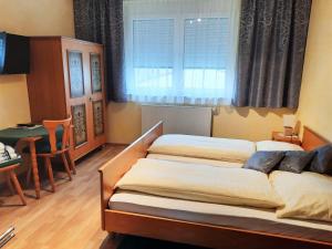 1 dormitorio con 2 camas, mesa y ventana en Gasthof Familie Hutter, en Rattersdorf