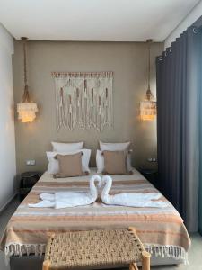 a bedroom with a bed with two swans on it at RIAD LE PATIO ROMANTIQUE in Marrakesh