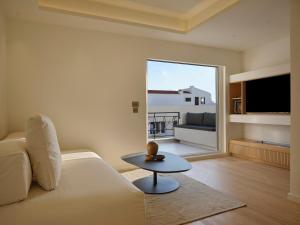 una sala de estar con un sofá y una mesa en Athenian Loft with Acropolis View, en Atenas
