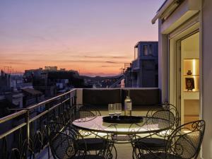 Una mesa y sillas en un balcón con vista. en Athenian Loft with Acropolis View, en Atenas