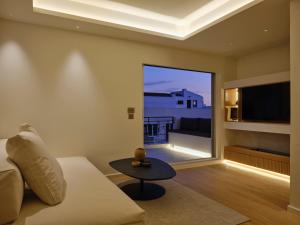 Una sala de estar con un sofá y una ventana grande. en Athenian Loft with Acropolis View, en Atenas