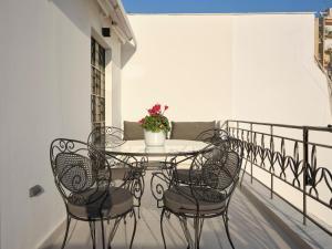 una mesa con sillas y una maceta en el balcón en Athenian Loft with Acropolis View, en Atenas