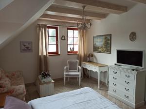 a bedroom with a bed and a desk with a television at Penzion Rozmarýn in Vsetín