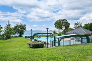 a swimming pool in a park with the ocean in the background at Duplex-Chalet entre Lac et Montagne - Balcon Vue Lac in Lugrin