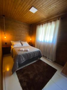 ein Schlafzimmer mit einem Bett mit zwei Hausschuhen darauf in der Unterkunft Aconchego Alto da Serra in Alfredo Wagner