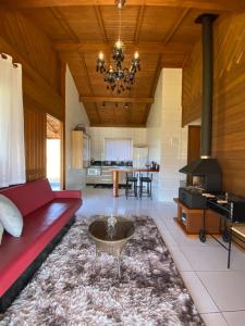 a living room with a red couch and a table at Aconchego Alto da Serra in Barracão