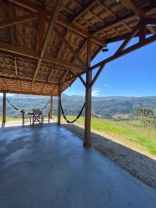 a porch with a hammock and a picnic table at Aconchego Alto da Serra in Alfredo Wagner
