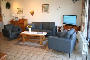 a living room with a couch and a table and a tv at Liguster 73* in Nieuwvliet
