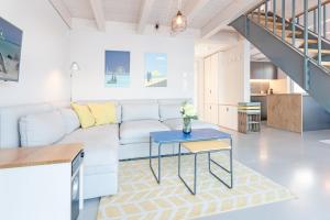 een woonkamer met een witte bank en een blauwe tafel bij Strandhus in Travemünde