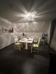 uma sala de jantar com uma mesa branca e cadeiras em Ferienwohnung Jodis em Bonerath