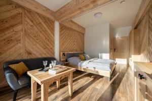 ein Schlafzimmer mit einem Bett, einem Sofa und einem Tisch in der Unterkunft Villa Tatrica in Kościelisko