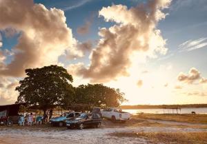 un grupo de coches estacionados junto a un cuerpo de agua en Granja Dona Dora, en Nísia Floresta