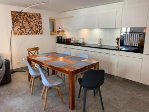 una cucina con tavolo e sedie in legno di Zusammen mit Freiraum - ENGADIN HOLIDAYS a Guarda
