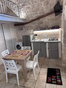 - une cuisine avec une table en bois et des chaises blanches dans l'établissement LA 13 guest house, à Ostuni