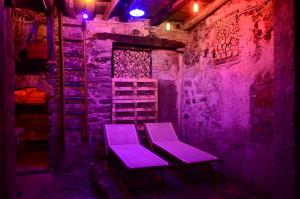 two purple chairs sitting in a room with purple lights at Casa Adriana in Oria