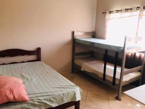 a bedroom with two bunk beds and a window at Chacara R. da Felicidade proximo ao thermas, aguas de sao pedro in Águas de São Pedro