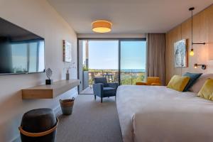 a hotel room with a bed and a view of the ocean at Les Jardins Du Cèdre in Port-Vendres